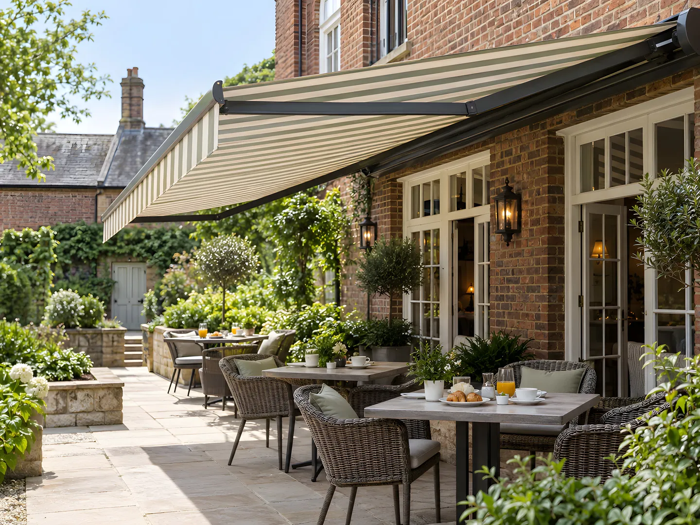 Striped retractable awning shading furnished hotel courtyard dining tables