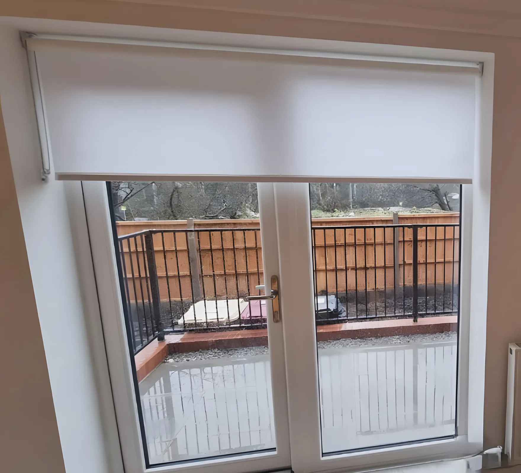 A wide dim-out roller blind fitted above the patio doors of a Bark Street house, terrace and railings beyond