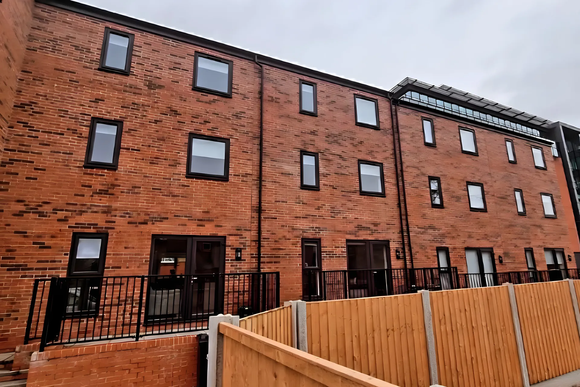 The red-brick terrace of new-build houses at Bark Street in Bolton with blinds fitted in the upper windows