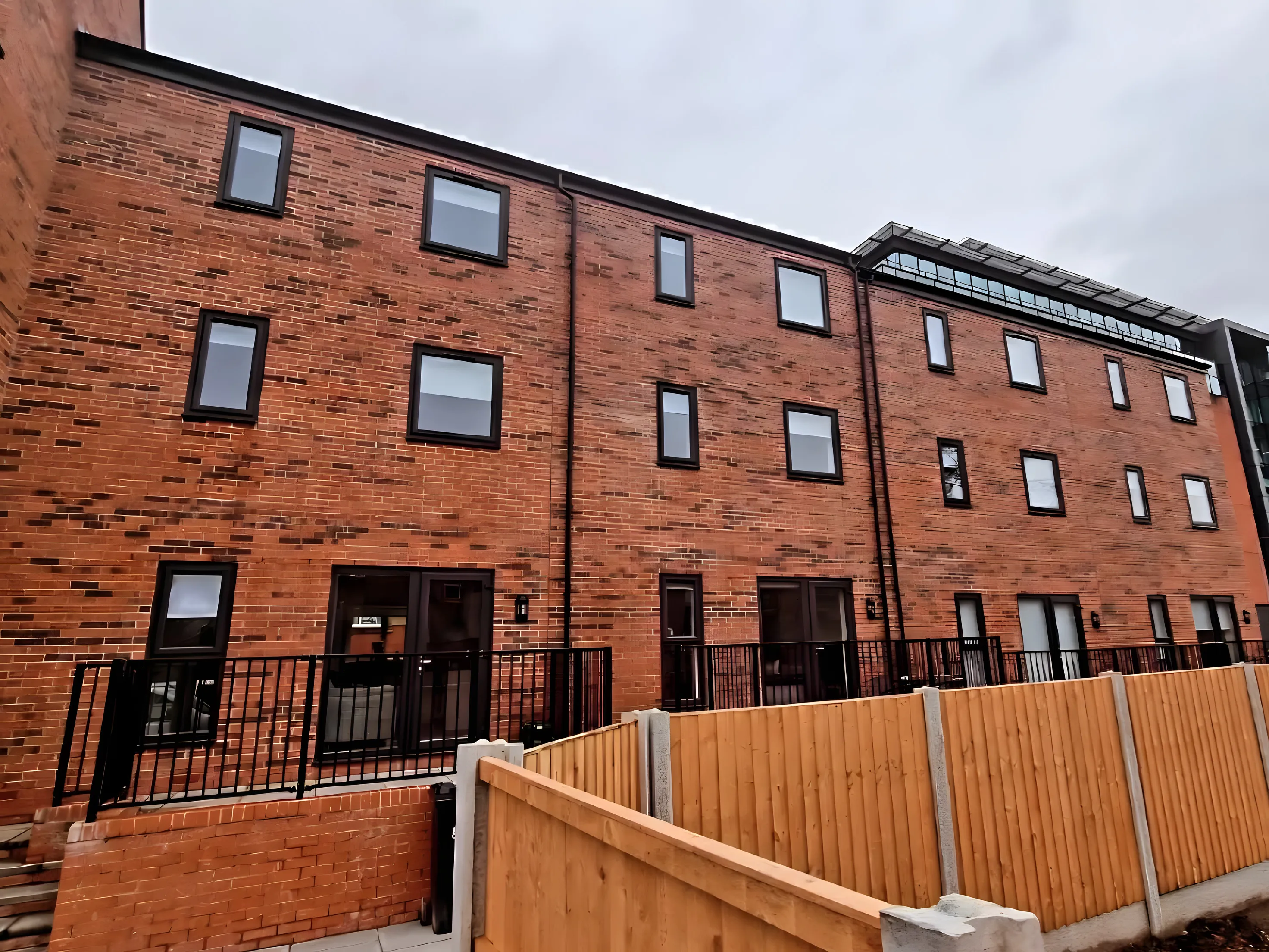 The red-brick terrace of new-build houses at Bark Street in Bolton with blinds fitted in the upper windows