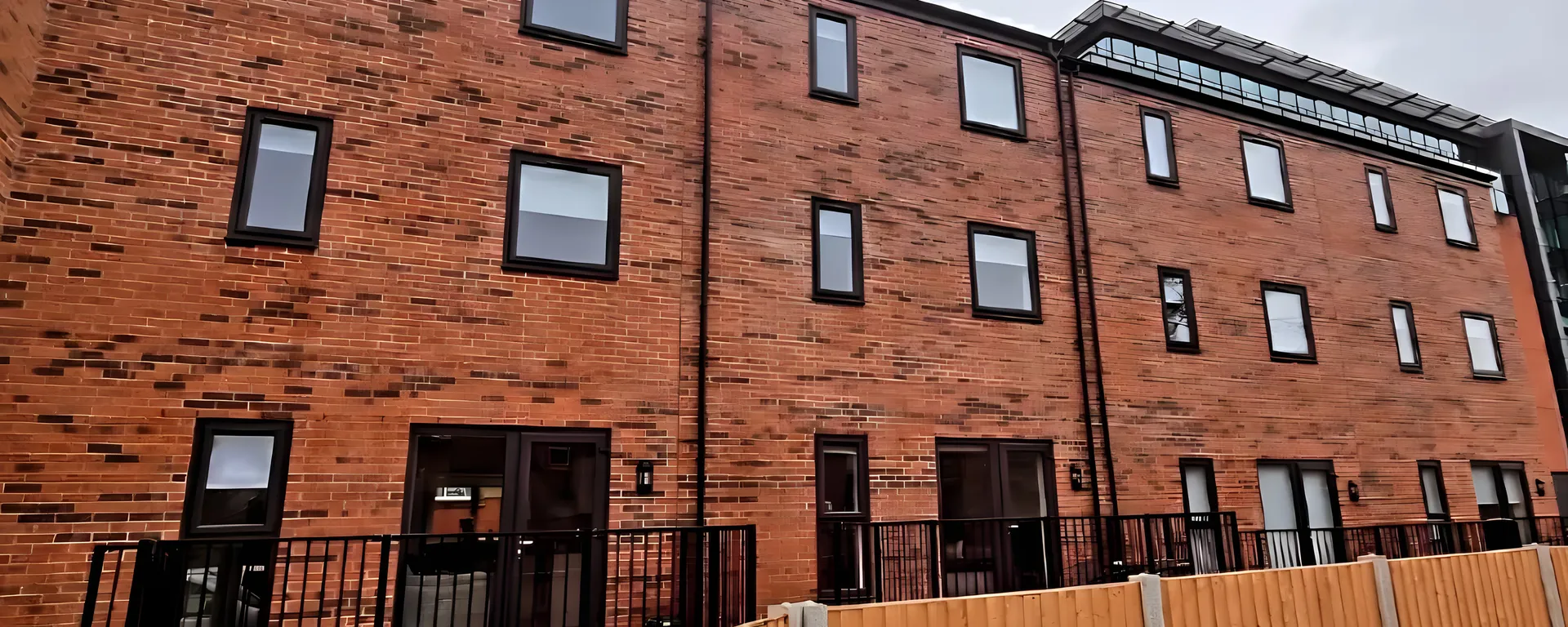 The red-brick terrace of new-build houses at Bark Street in Bolton with blinds fitted in the upper windows
