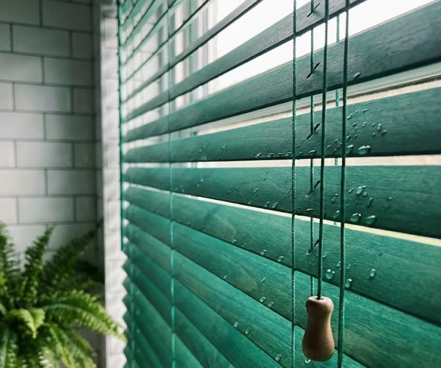 Green moisture-suitable blind slats beside bathroom tiles