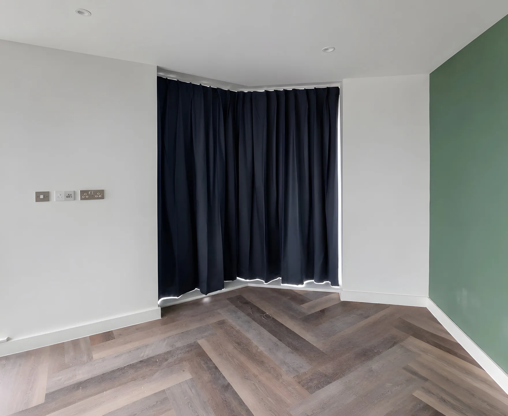 Dark grey curtains hung across the corner glazing of an apartment at Cale Cross in Newcastle