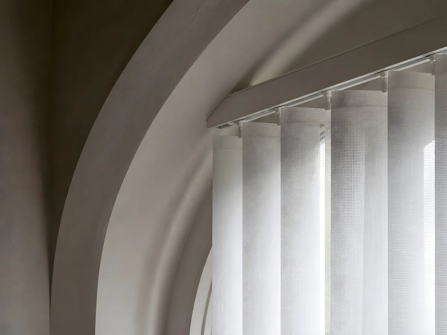 Pale vertical blinds fitted beneath tall arched church windows