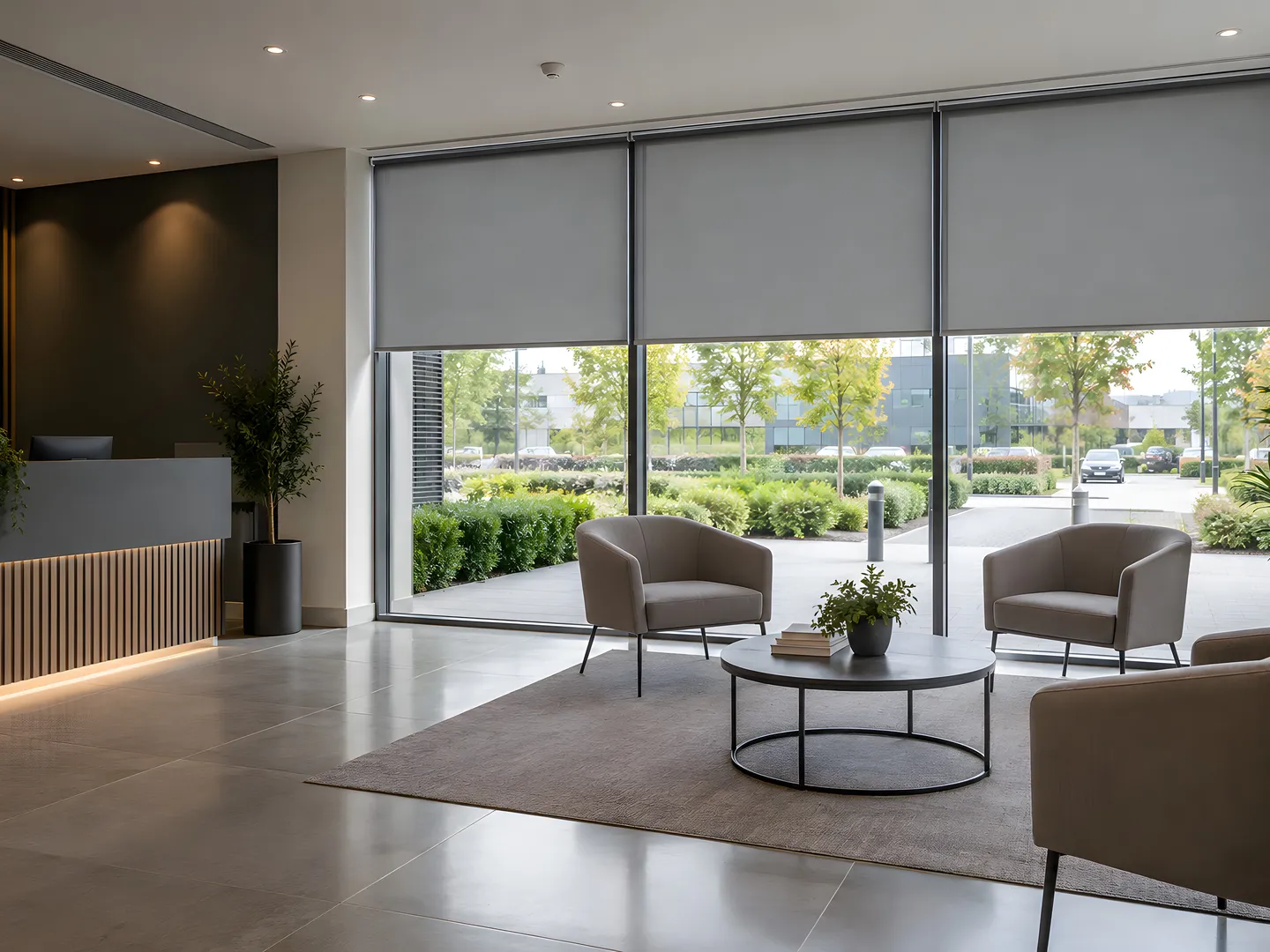 Coordinated grey roller blinds in a furnished commercial reception