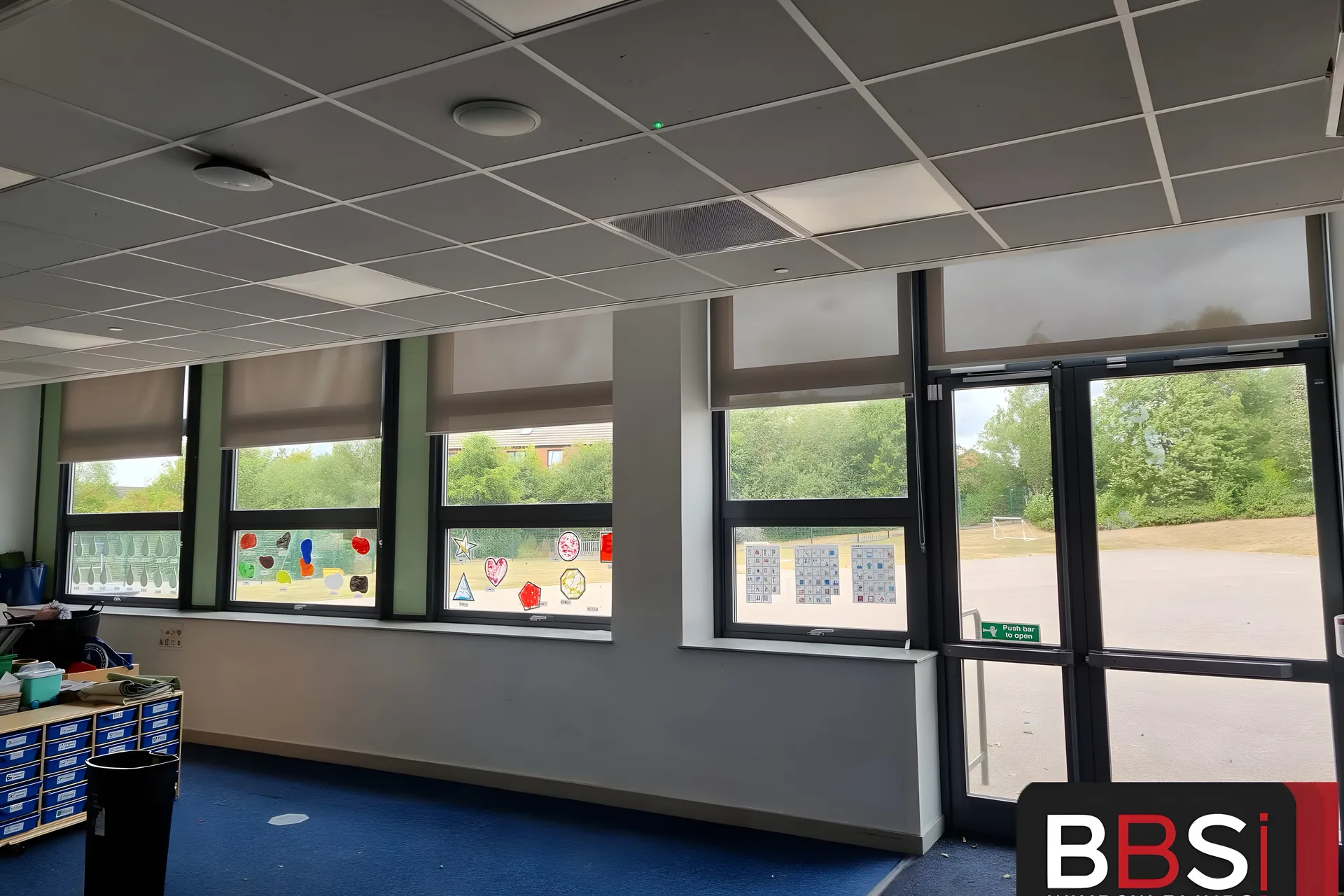 Roller blinds fitted across a run of classroom windows and the glazed external door at The Grange Academy