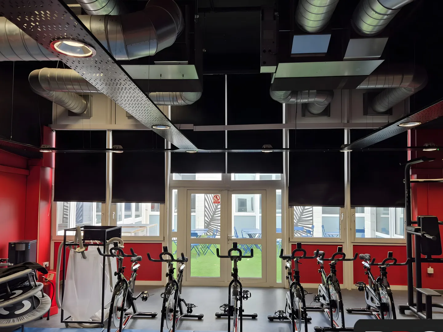 Dark roller blinds behind spin bikes in a fitted gym studio