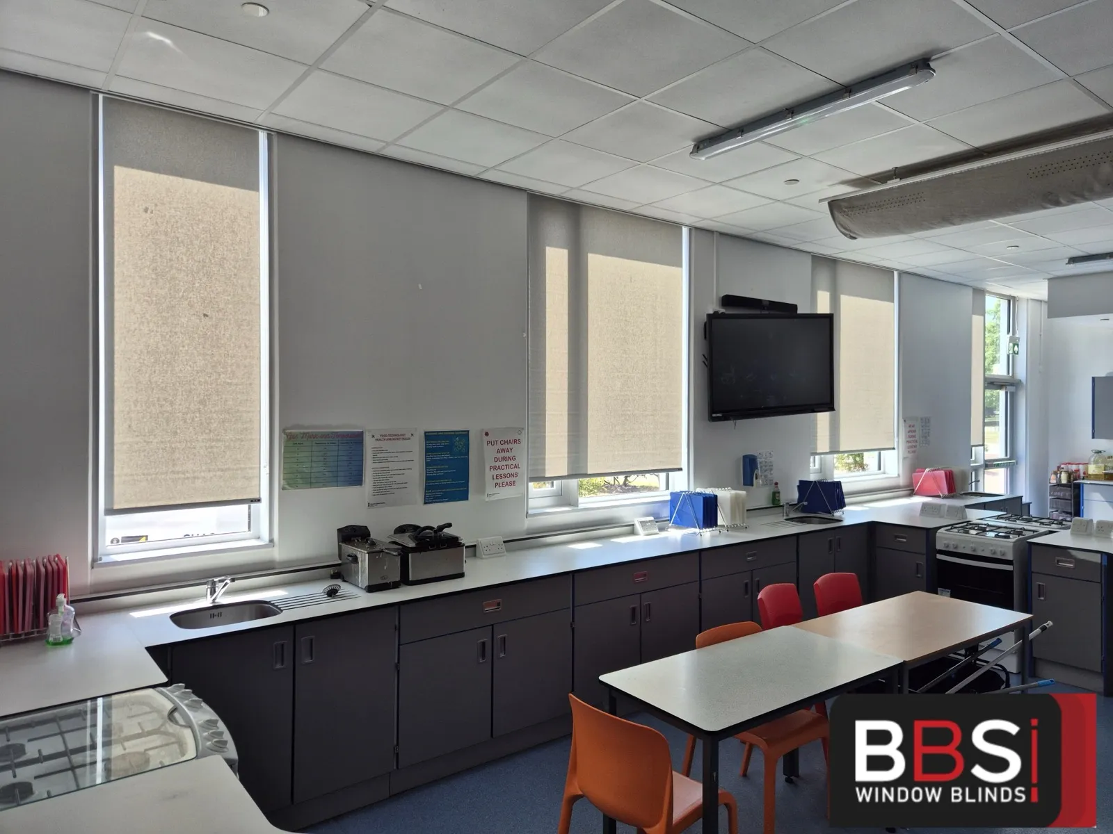 Food technology room with roller blinds above the worktop run of sinks, cookers and preparation benches