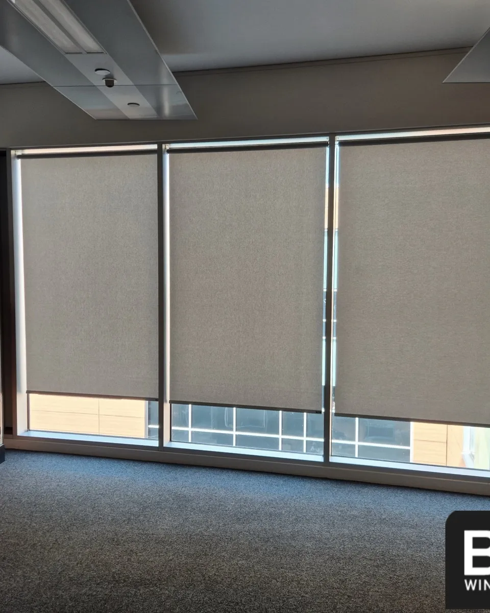 Three matching roller blinds across a full window wall next to a bank of lockers at Irlam and Cadishead High School
