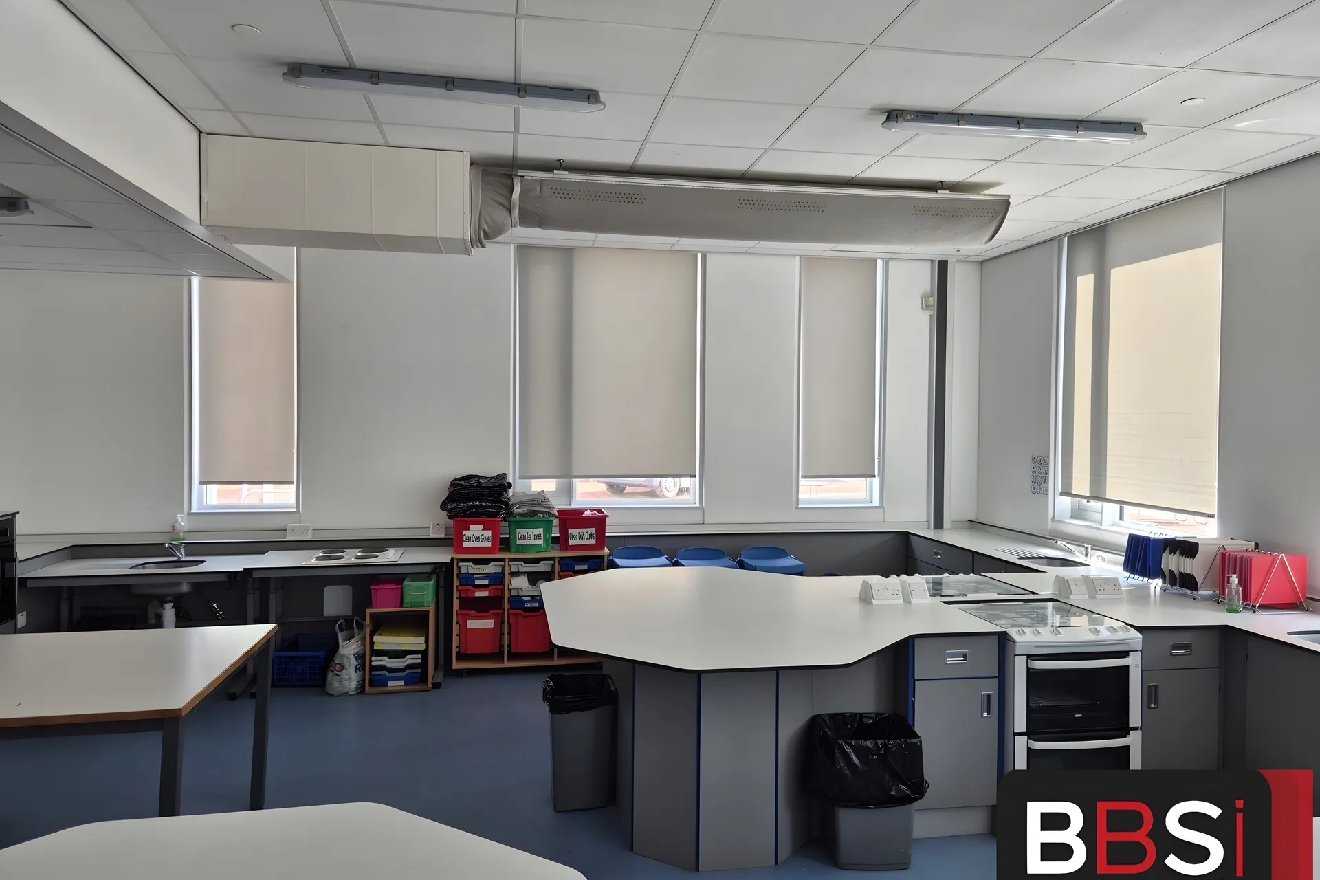 Food technology room at Irlam and Cadishead High School with roller blinds along the window wall beneath the extraction canopy