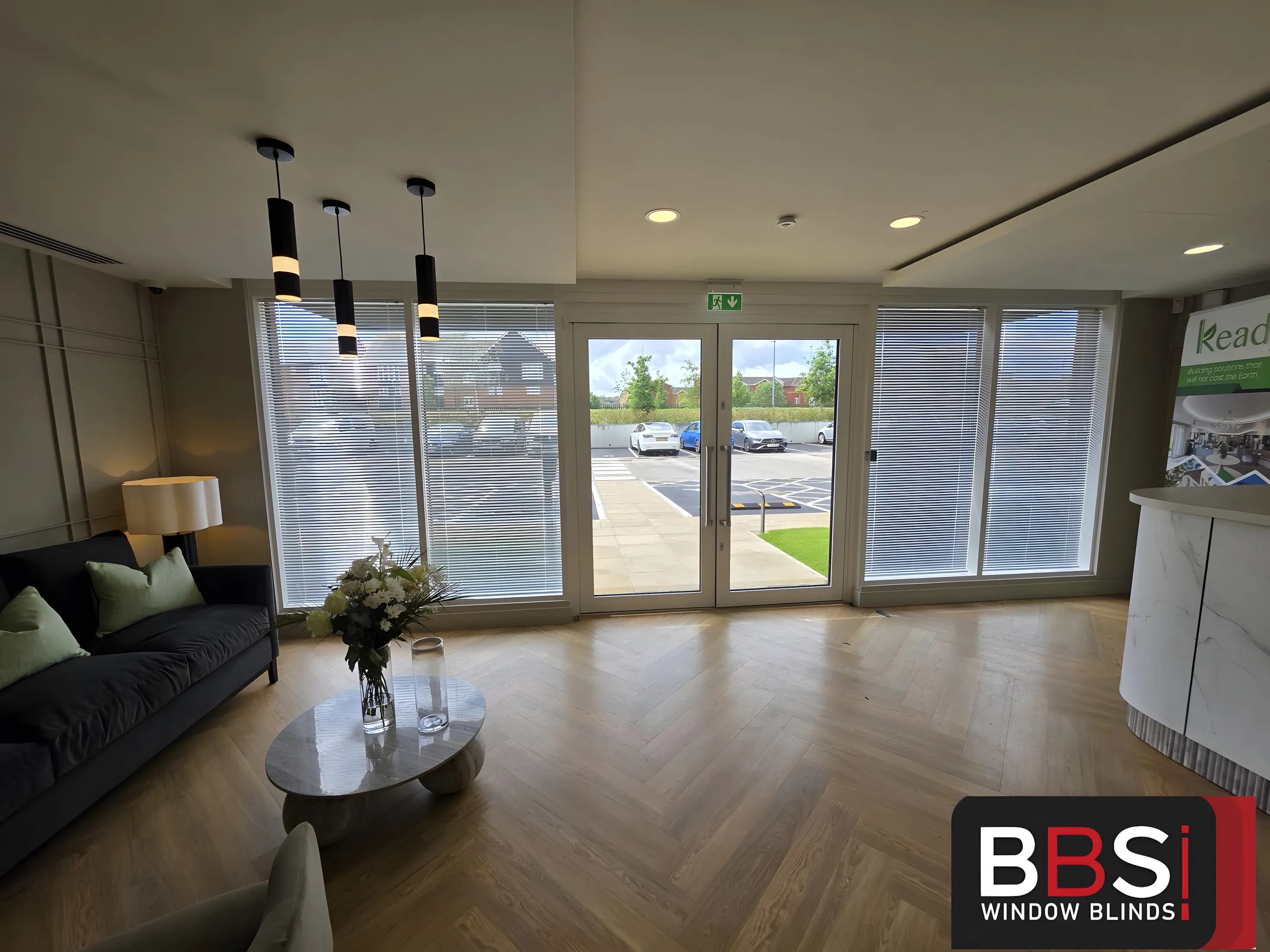 Reception area at Keady Construction HQ with free hang venetian blinds across the glazed entrance wall