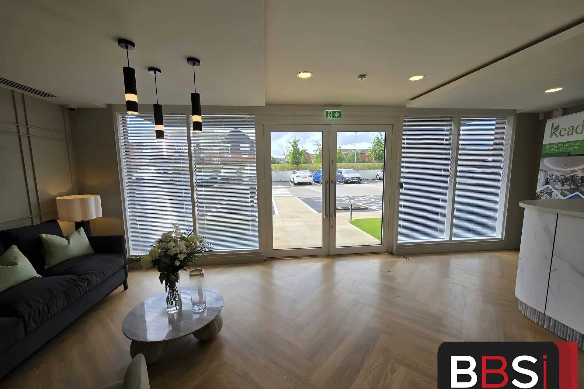 Reception area at Keady Construction HQ with free hang venetian blinds across the glazed entrance wall
