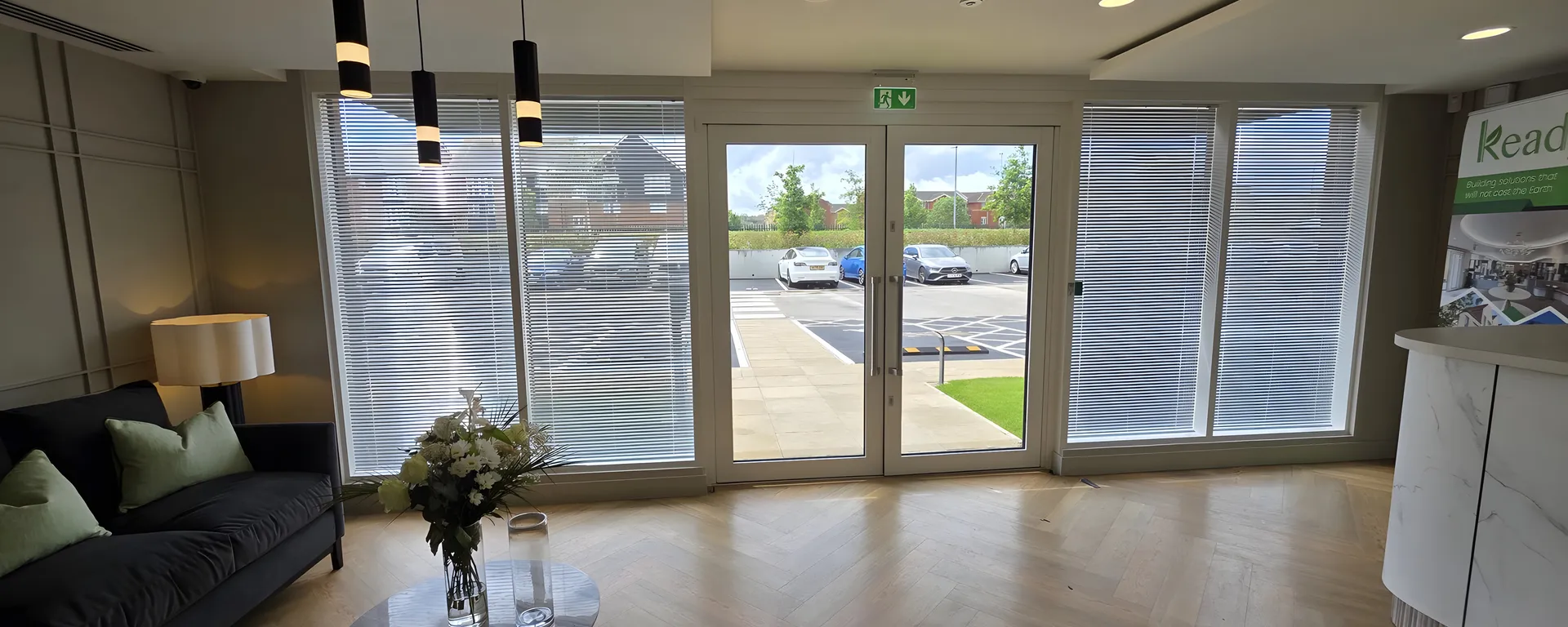 Reception area at Keady Construction HQ with free hang venetian blinds across the glazed entrance wall
