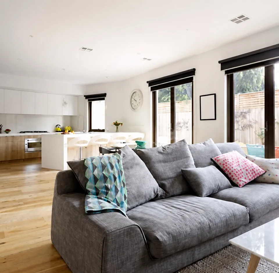 Dark roller blinds shown in a furnished living room