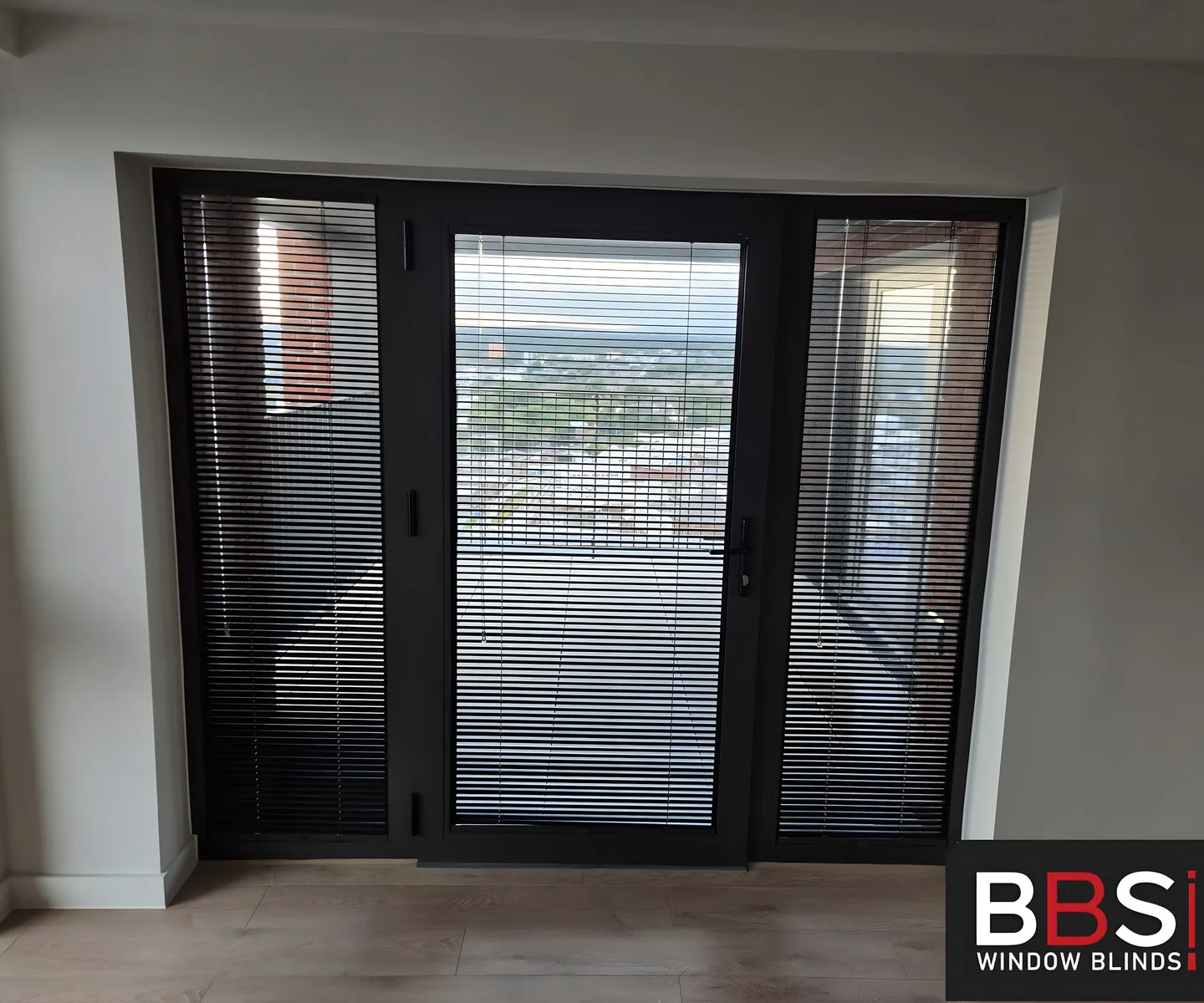 Perfect Fit Venetians on a balcony door and side panels with the Manchester skyline behind