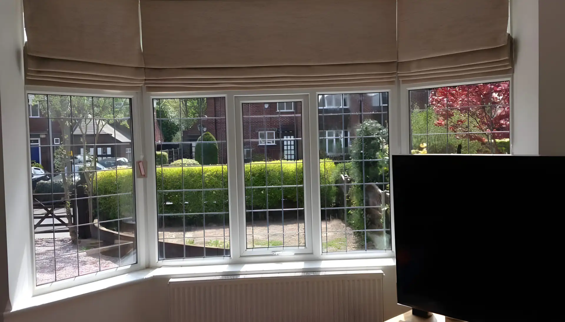 BBS Roman blinds fitted across a leaded bay window in a family home