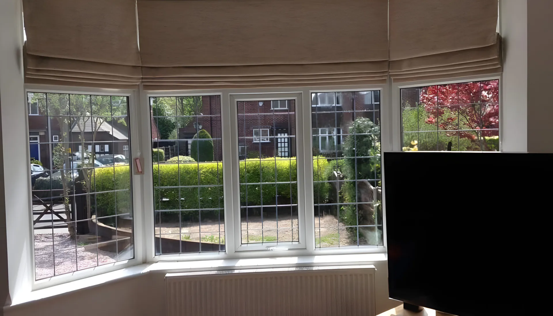 BBS Roman blinds fitted across a leaded bay window in a family home