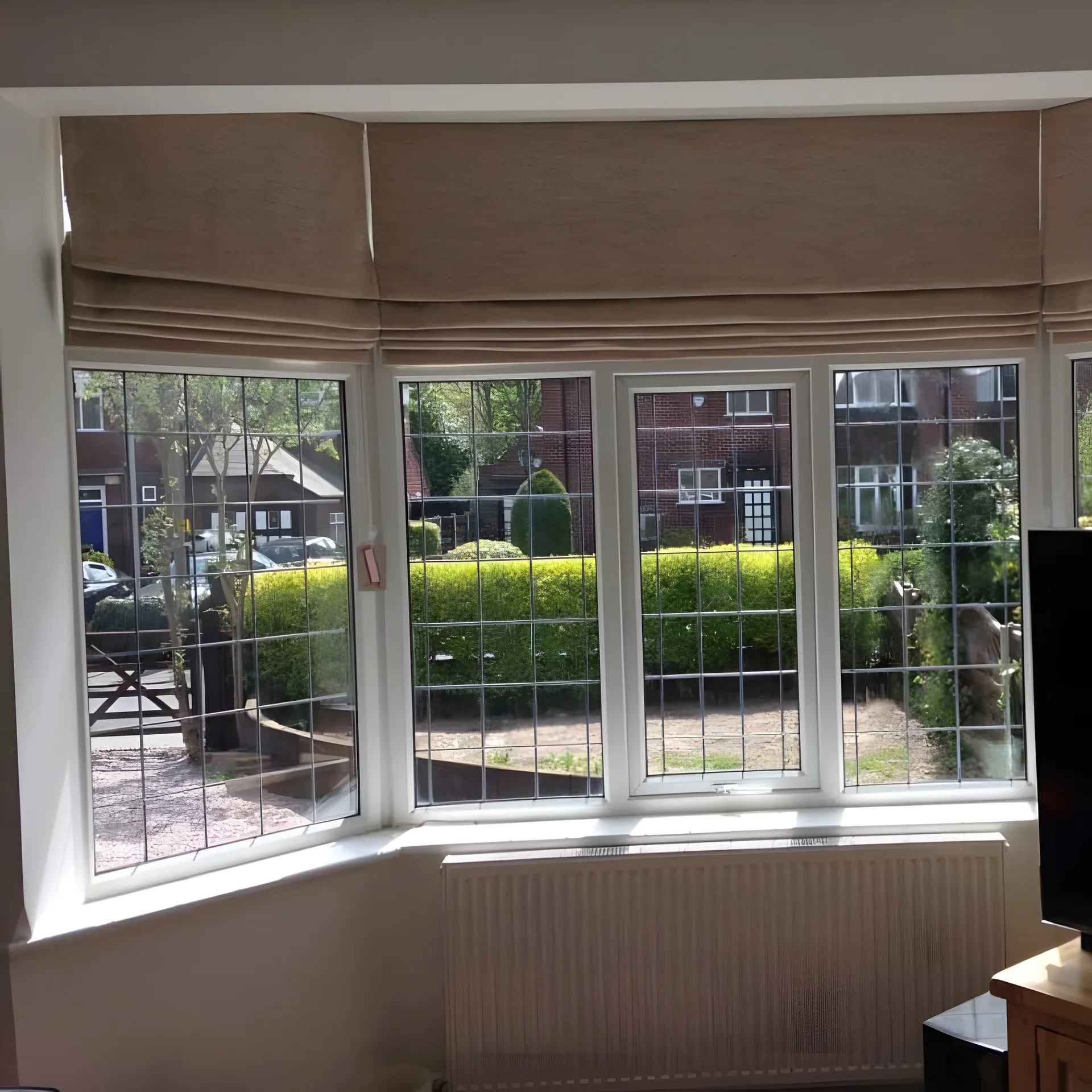 BBS Roman blinds fitted across a leaded bay window in a family home