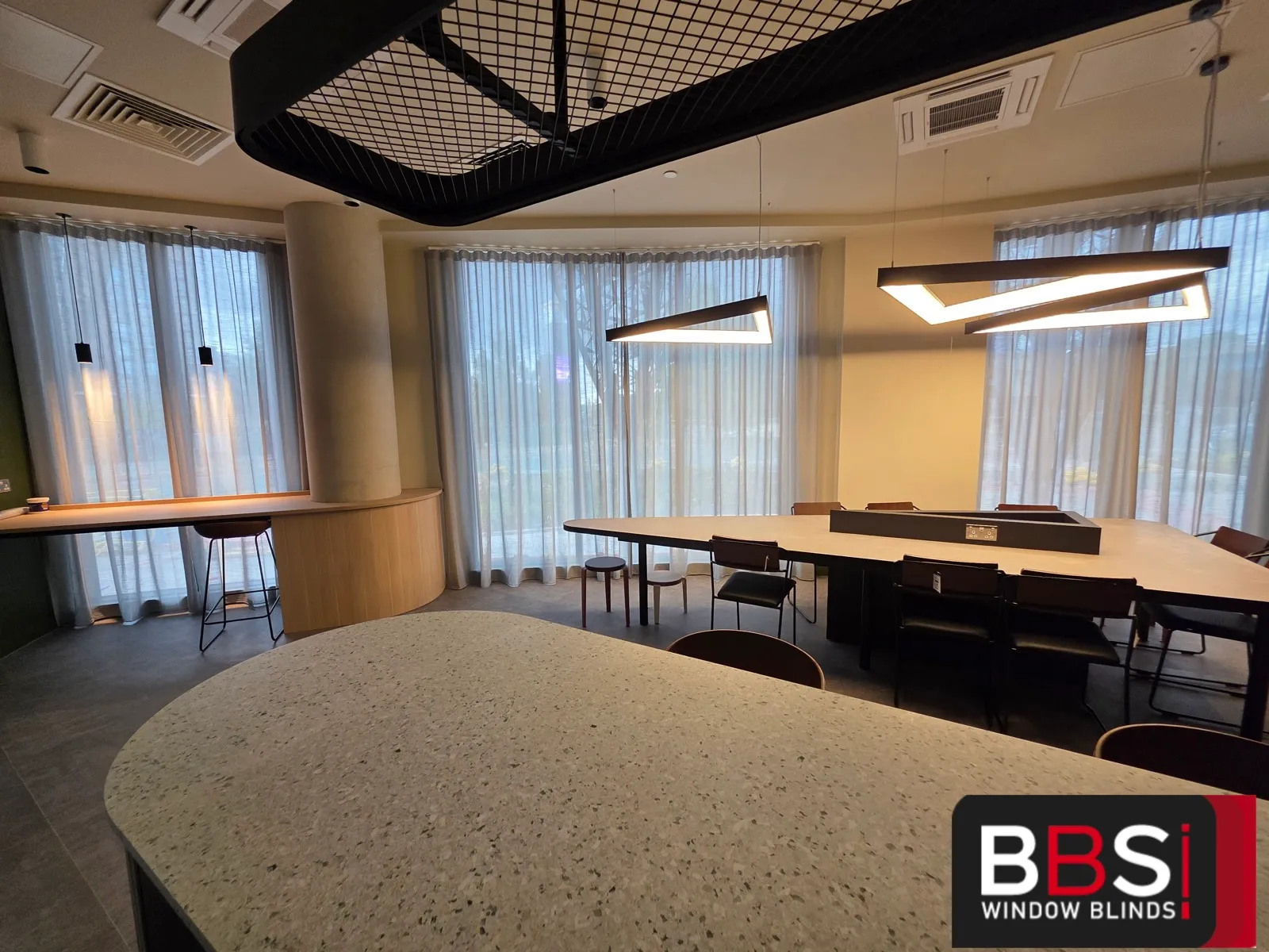 Co-working floor at Skinner Street with wave sheers running around a curved bay behind long shared tables