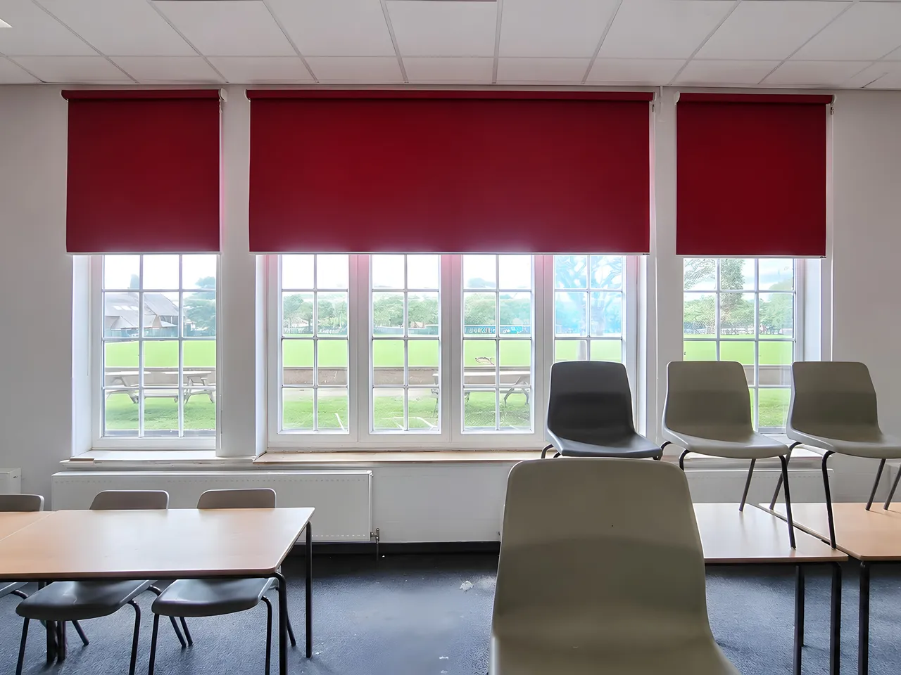 Red roller blinds fitted in a modern UK classroom