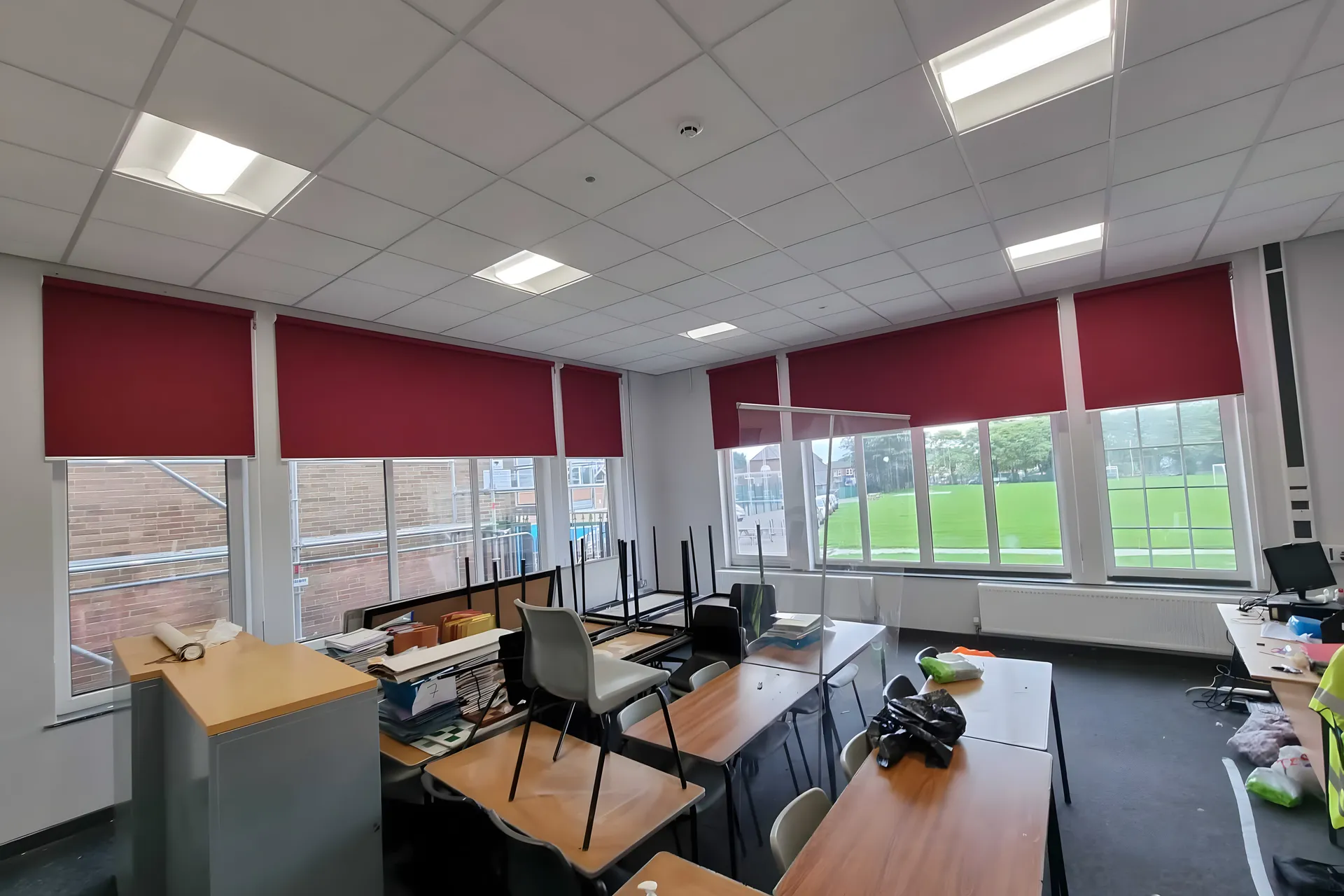 Red roller blinds fitted across classroom windows at Stockport School