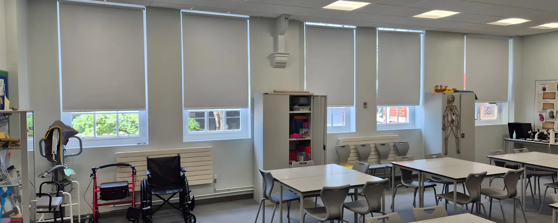 Health and social care training room at Worsley College with a run of white PVC blackout blinds above wheelchair and walking frame equipment